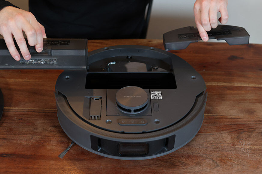 Резервуар для воды и пылесборник Dreame L10s стоят рядом на полу.